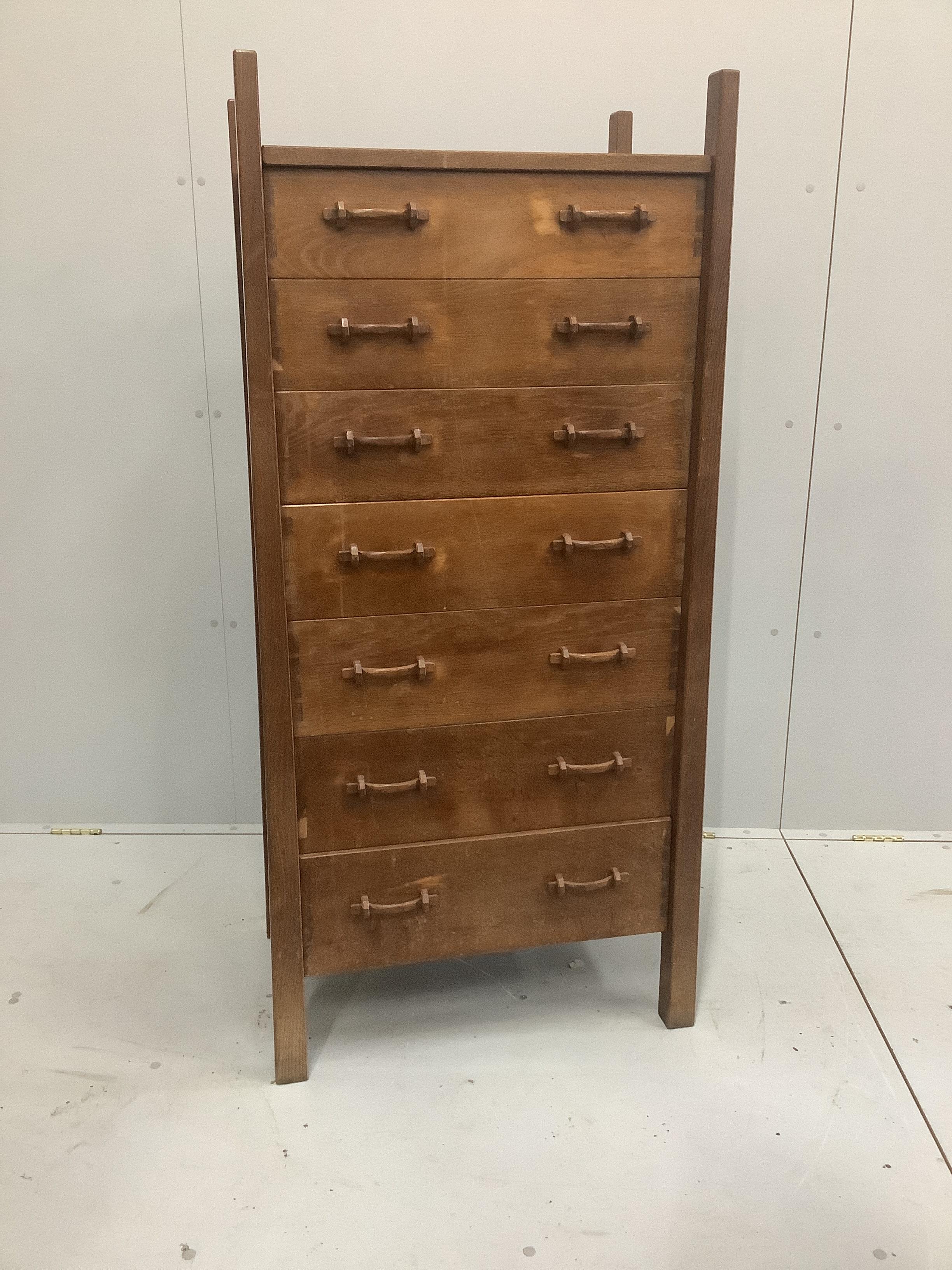 An Arts & Crafts oak seven drawer chest by Lawrence Tweedie of Derbyshire, width 67cm, height 142cm